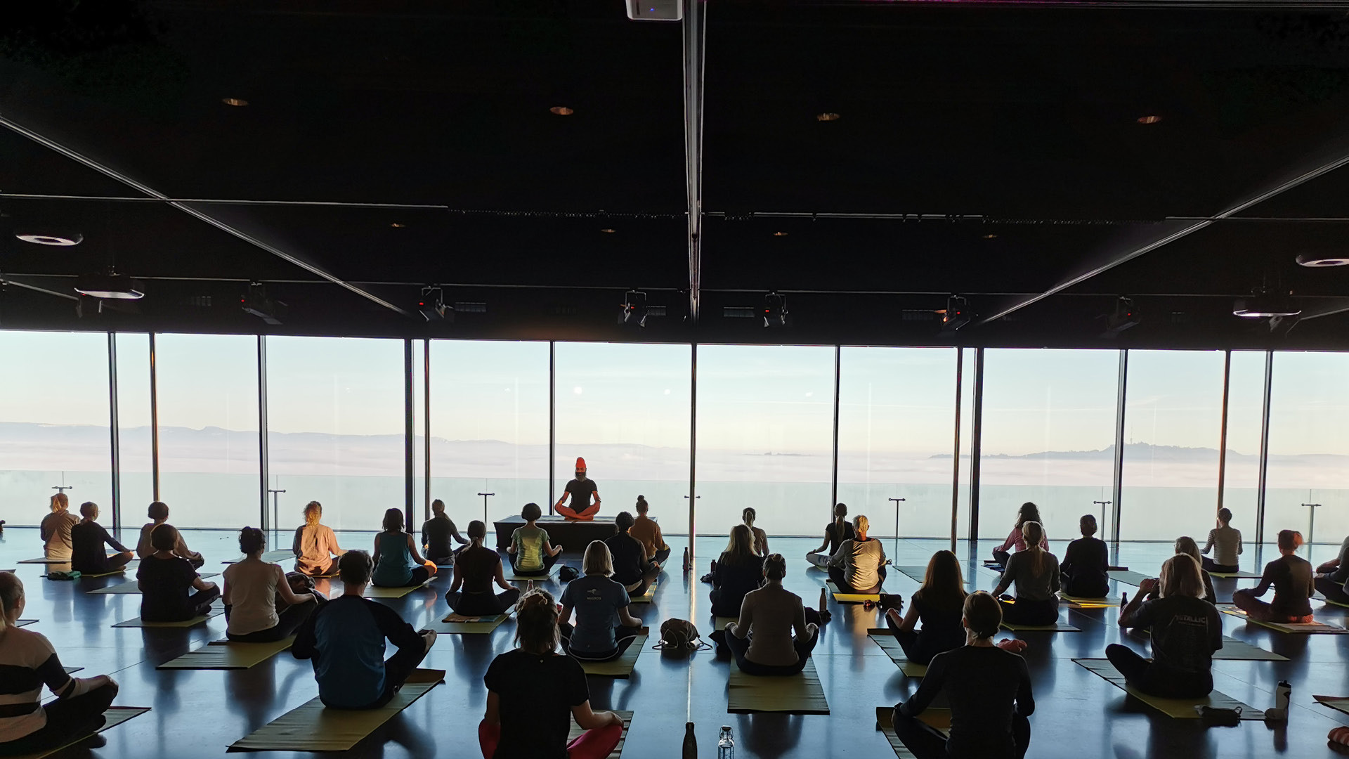 Mehrere Personen welche in der Eventlocation Pavilon beim Yoga Brunch Yoga machen und meditieren sind auf dem Bild.