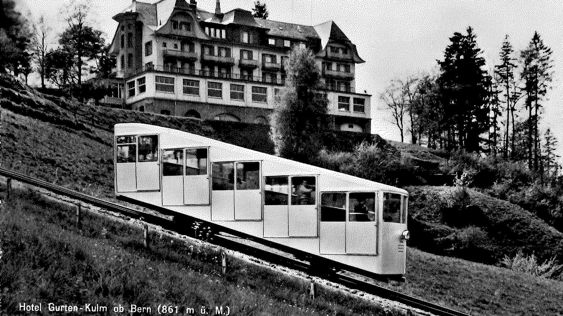 Die alte Gurtenbahn fahrend vor dem Kulm-Gebäude in schwarzweiss.