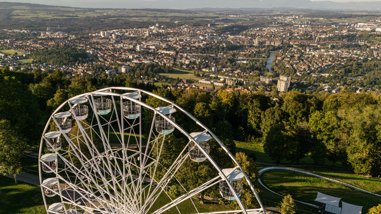 Das Riesenrad bei Tag und die Stadt Bern.