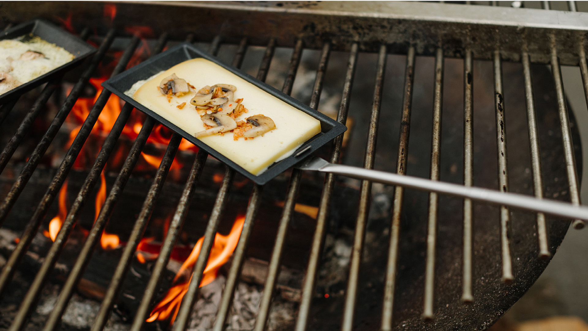 Raclette Pfannen über Feuergrill