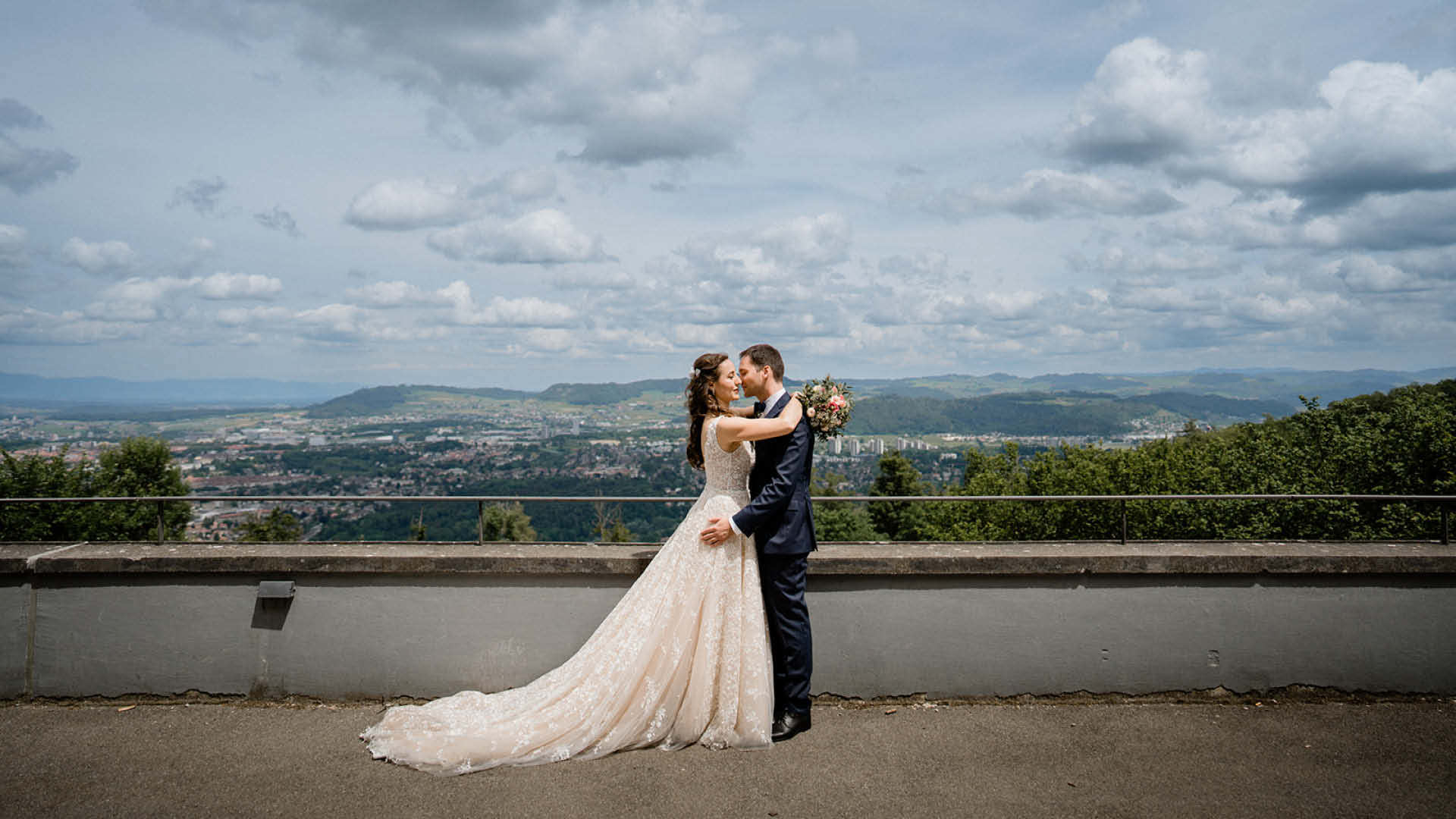 Ein Hochzeitspaar posiert für ein Bild mit Aussicht auf Bern und das Mittelland.