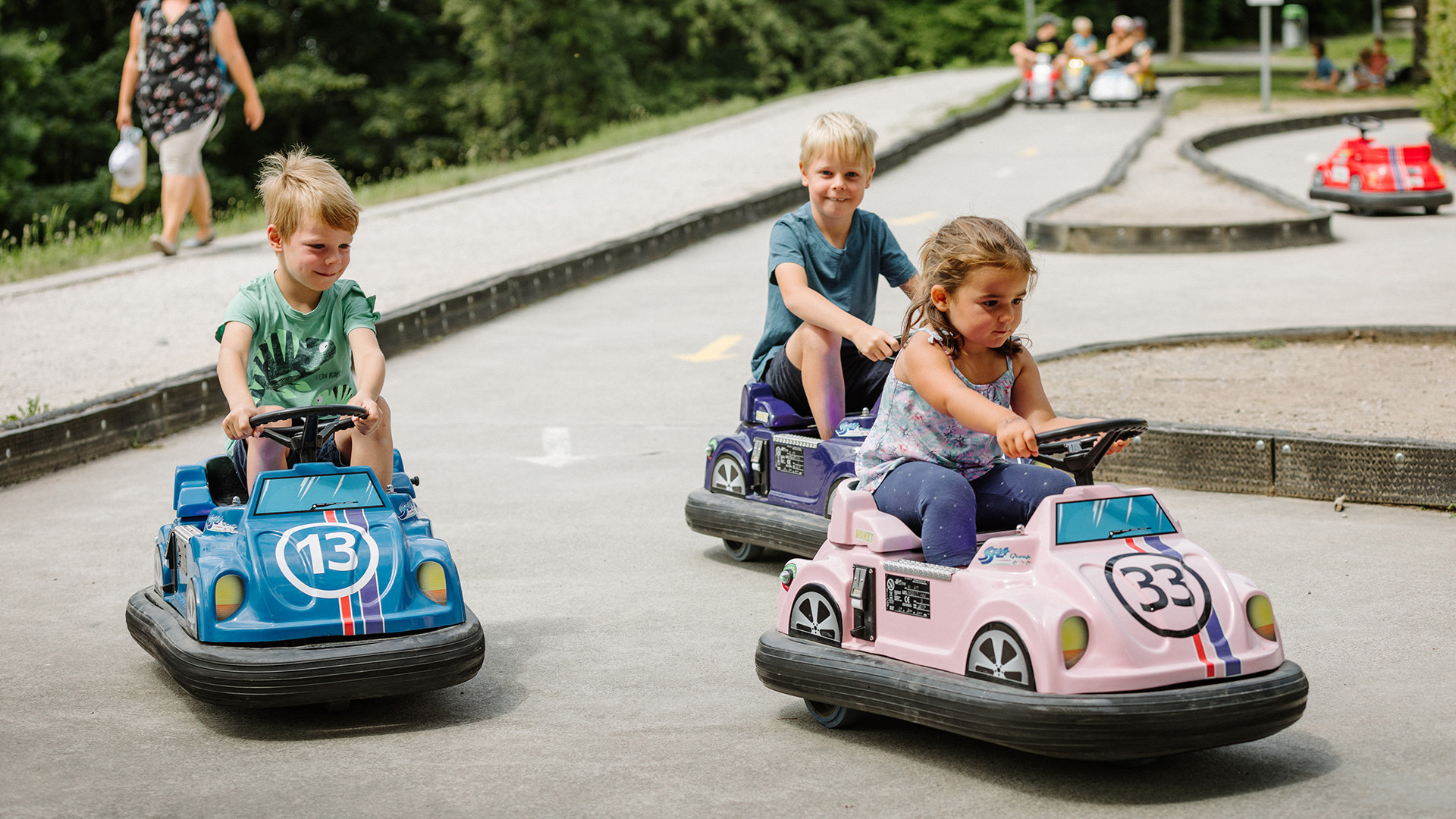Drei Kinder fahren alle in gleiche Richtung auf Kids Car