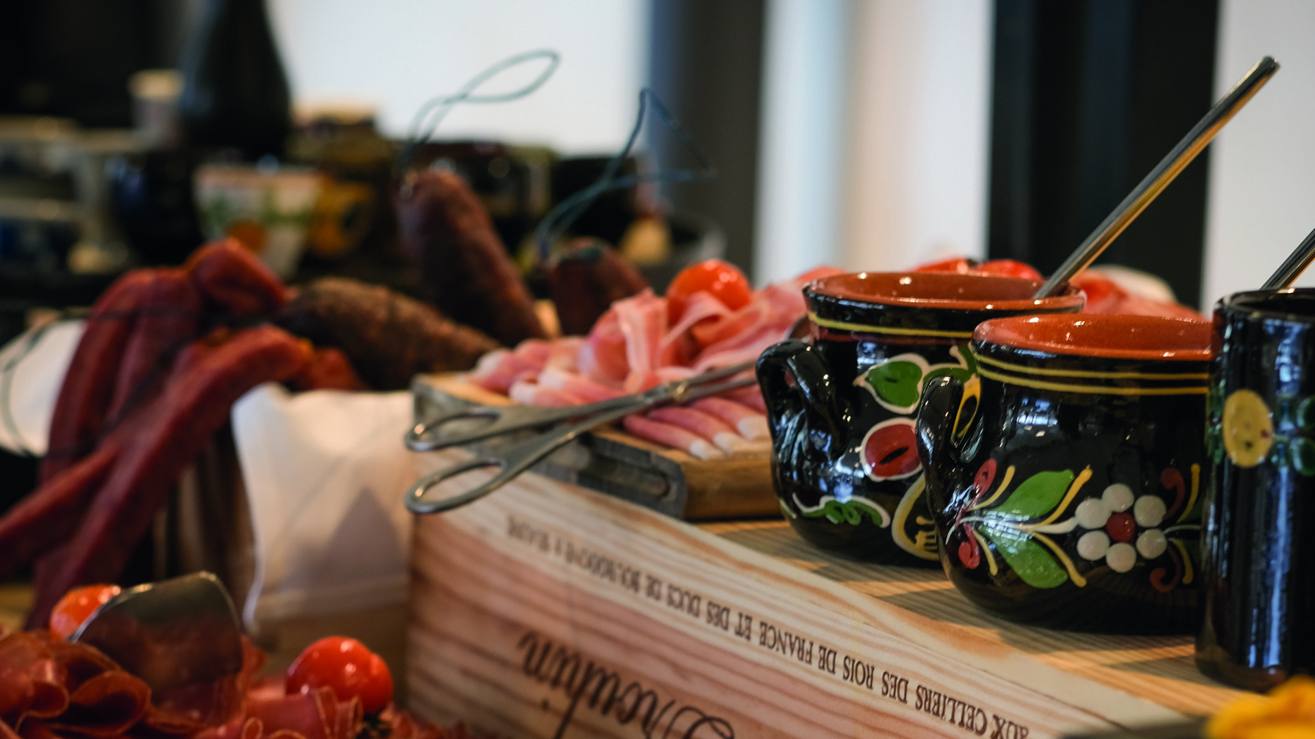 Eine Nahaufnahme des Schüür-Bunchs. Zusehen sind diverse Würste, Fleisch, und mehrere Tongefässe.