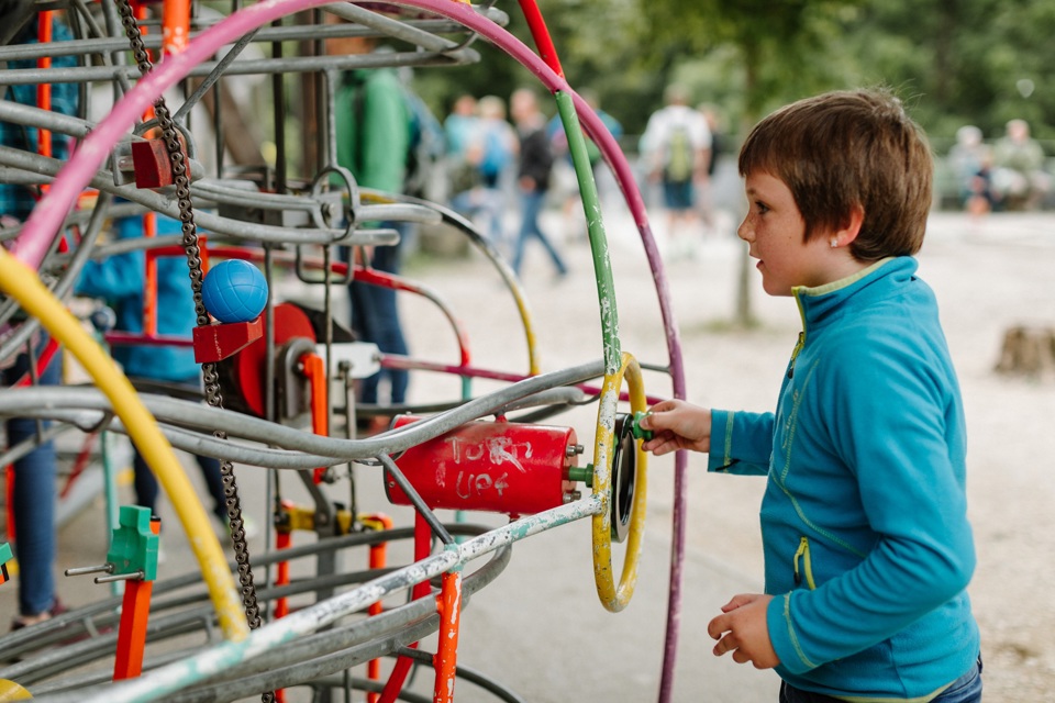 Ein Junge spielt an der Kugelbahn auf dem Spielpark