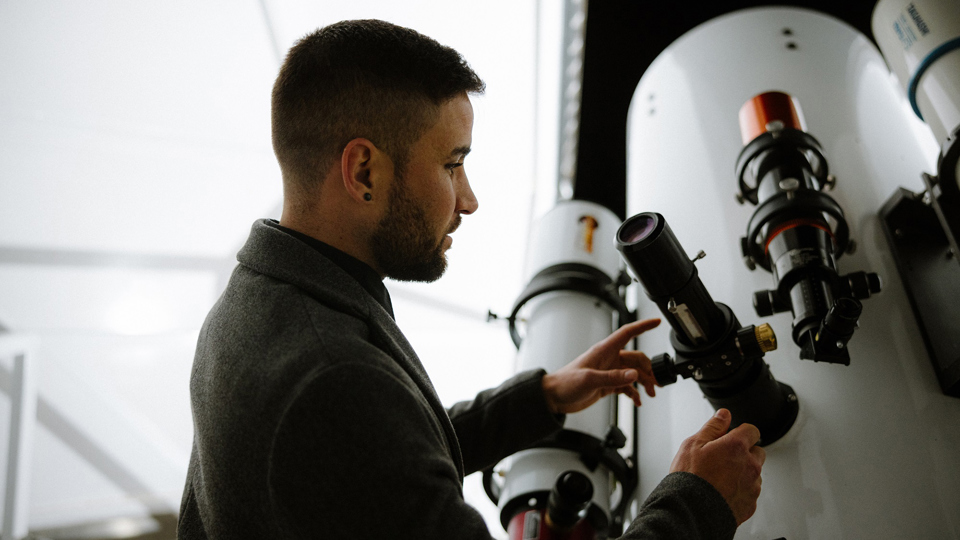 Eine Person welche das Teleskop erklärt bekommt.