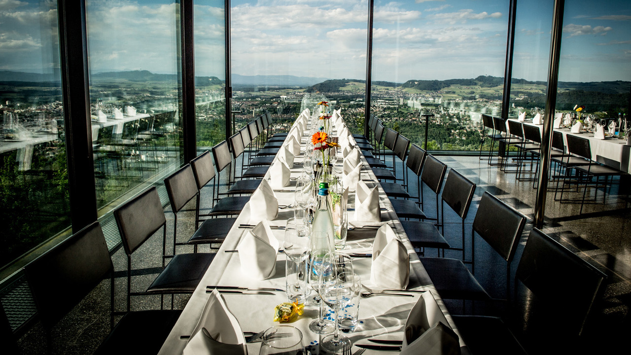 Gedeckte Tischreihe an Fensterfront