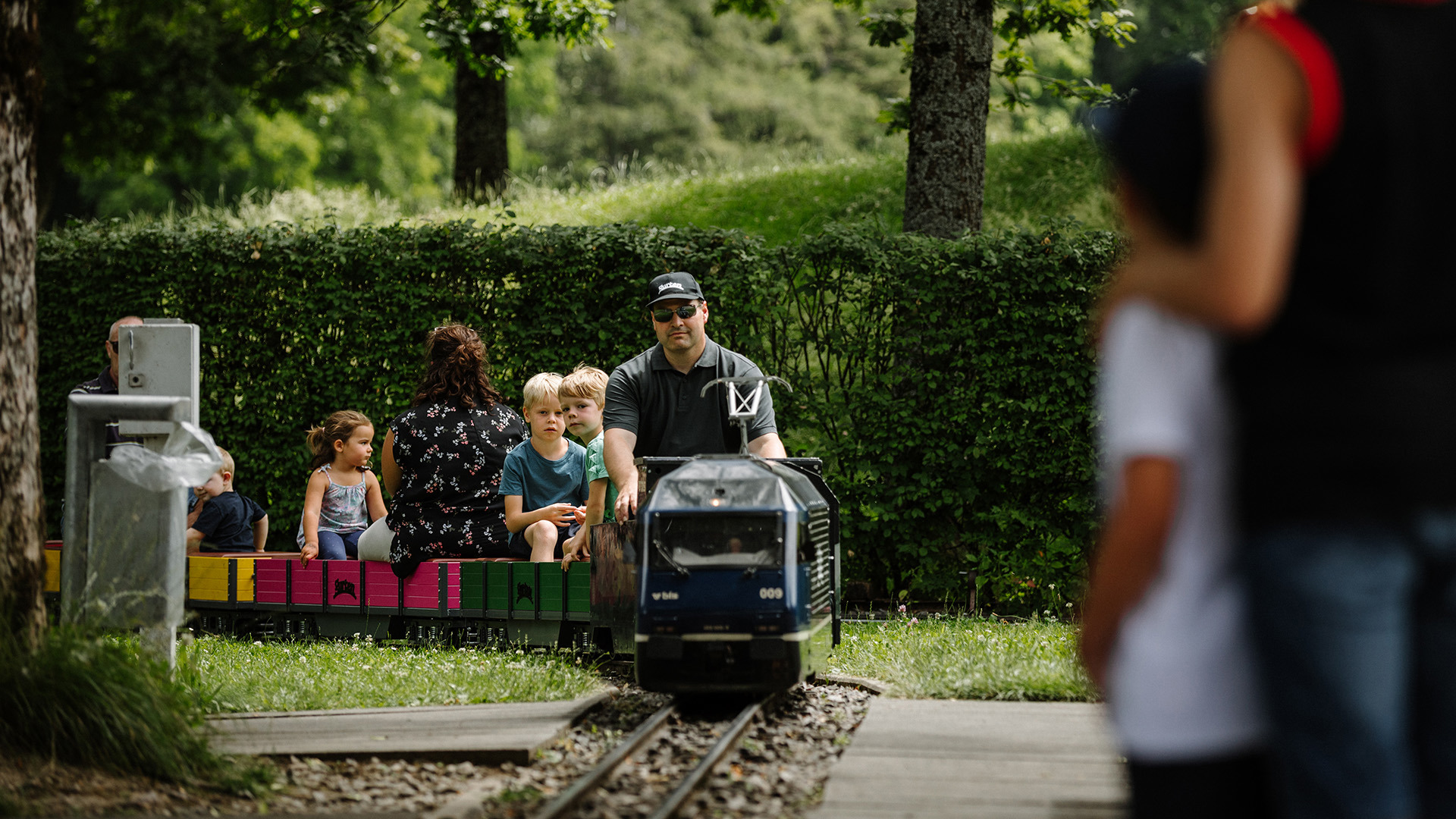 Kleineisenbahn mit Passagieren fährt in Bahnhof