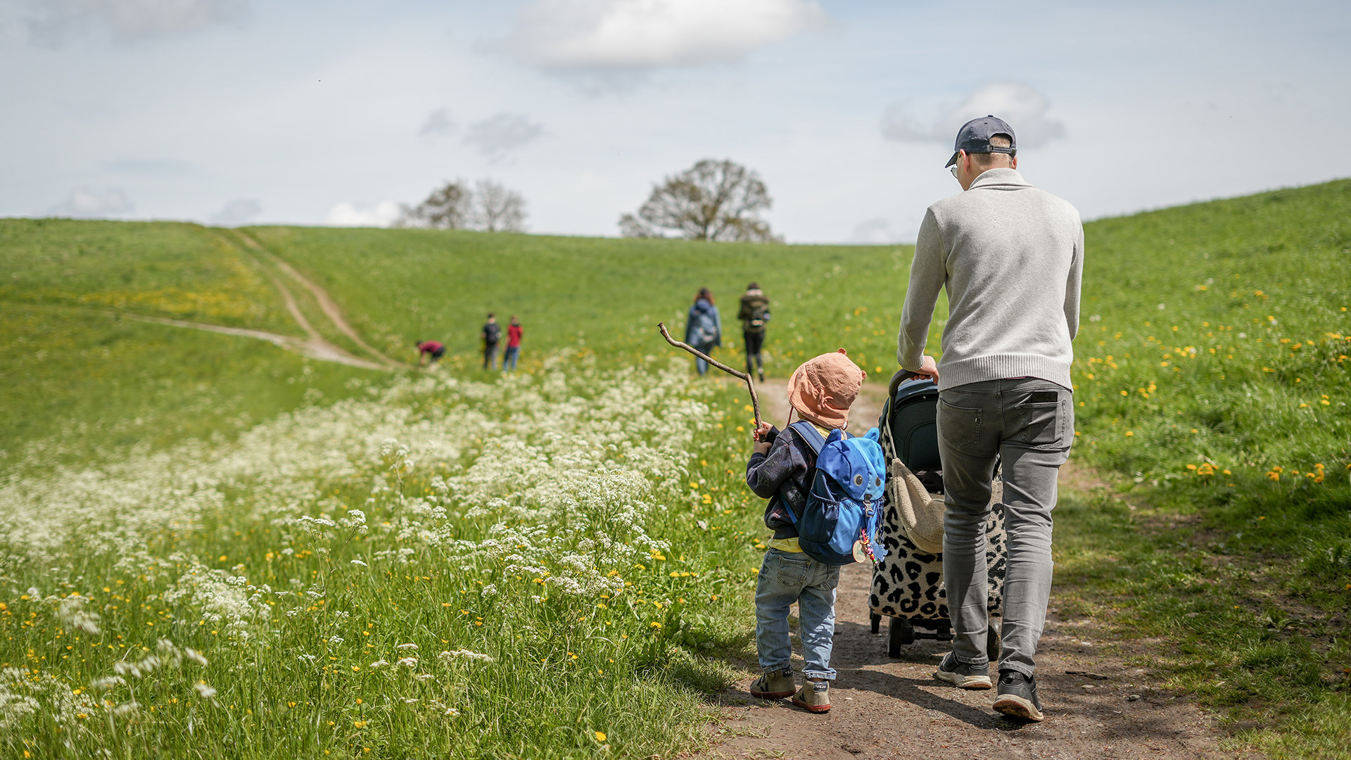 Ein Vater wandert mit seinenen Kindern den Gurten hoch.