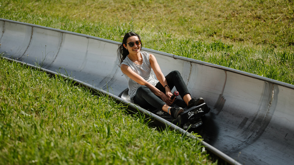 Eine junge Frau geniesst die Fahrt auf der Rodelbahn