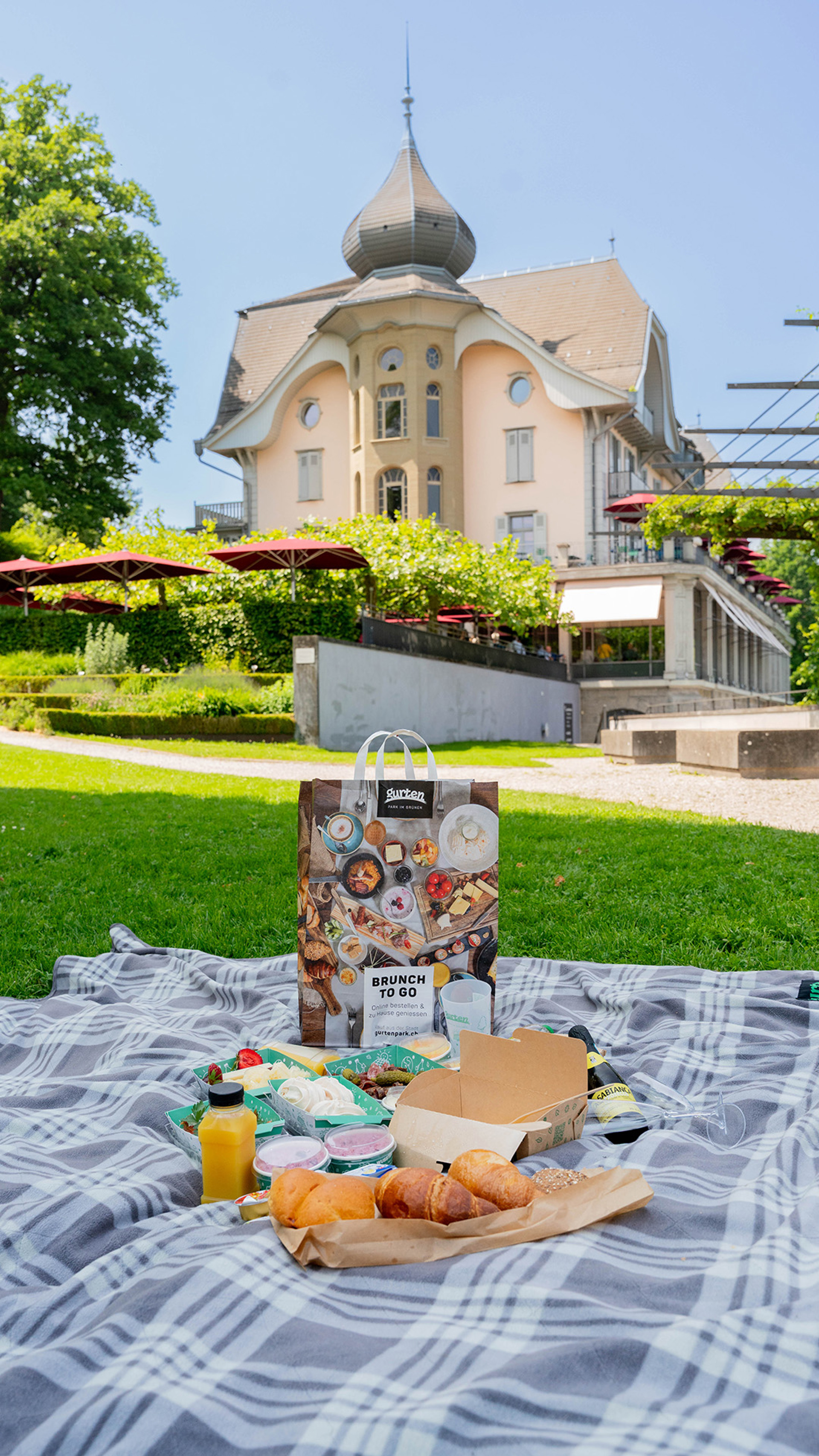 Eine Brunch-Tasche auf einer Picknickdecke mit dem Kulm-Gebäude im Hintergrund