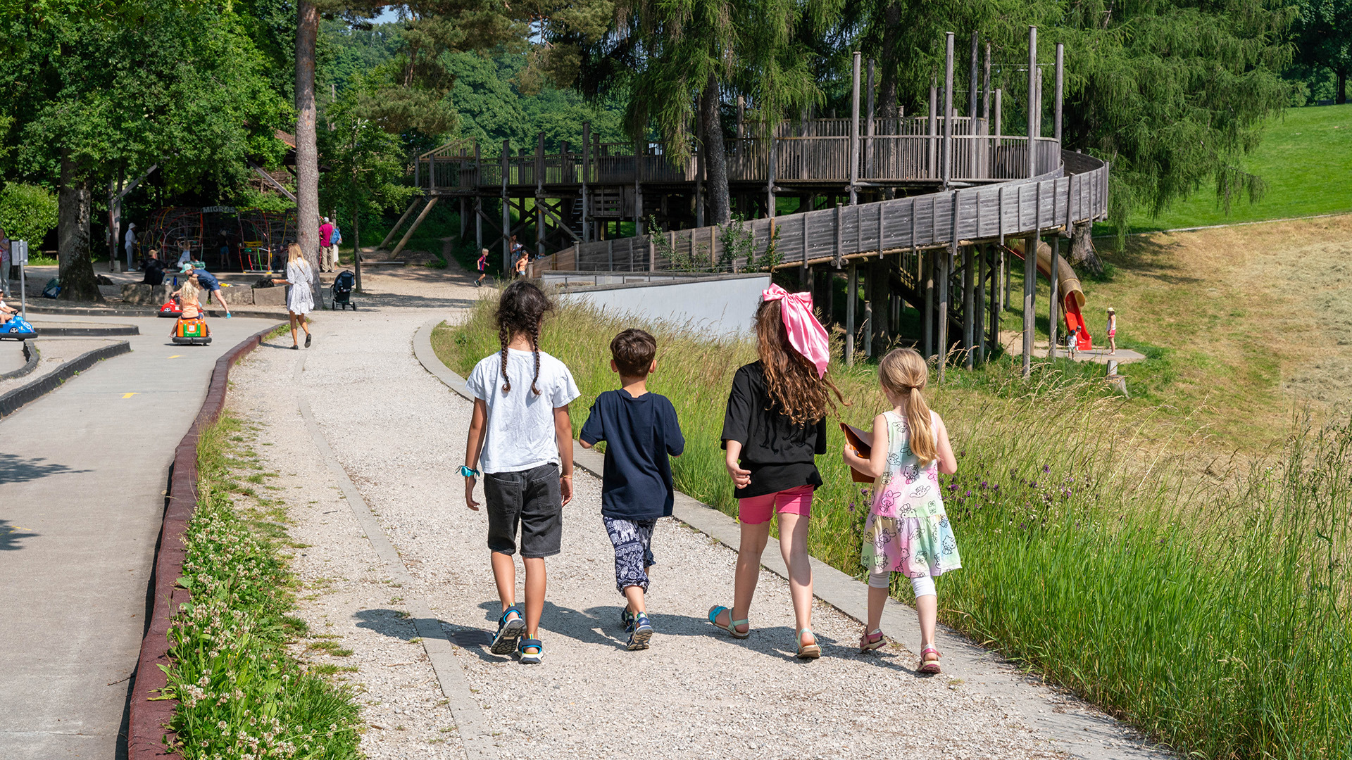 Four children walking across a playground at Kids Car