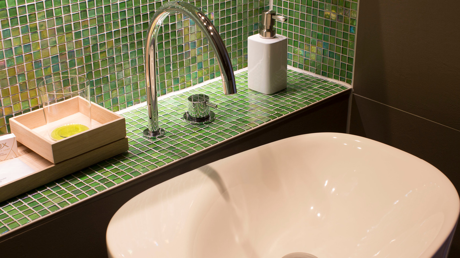 Das Badezimmer ist stylisch in grün gehalten. 