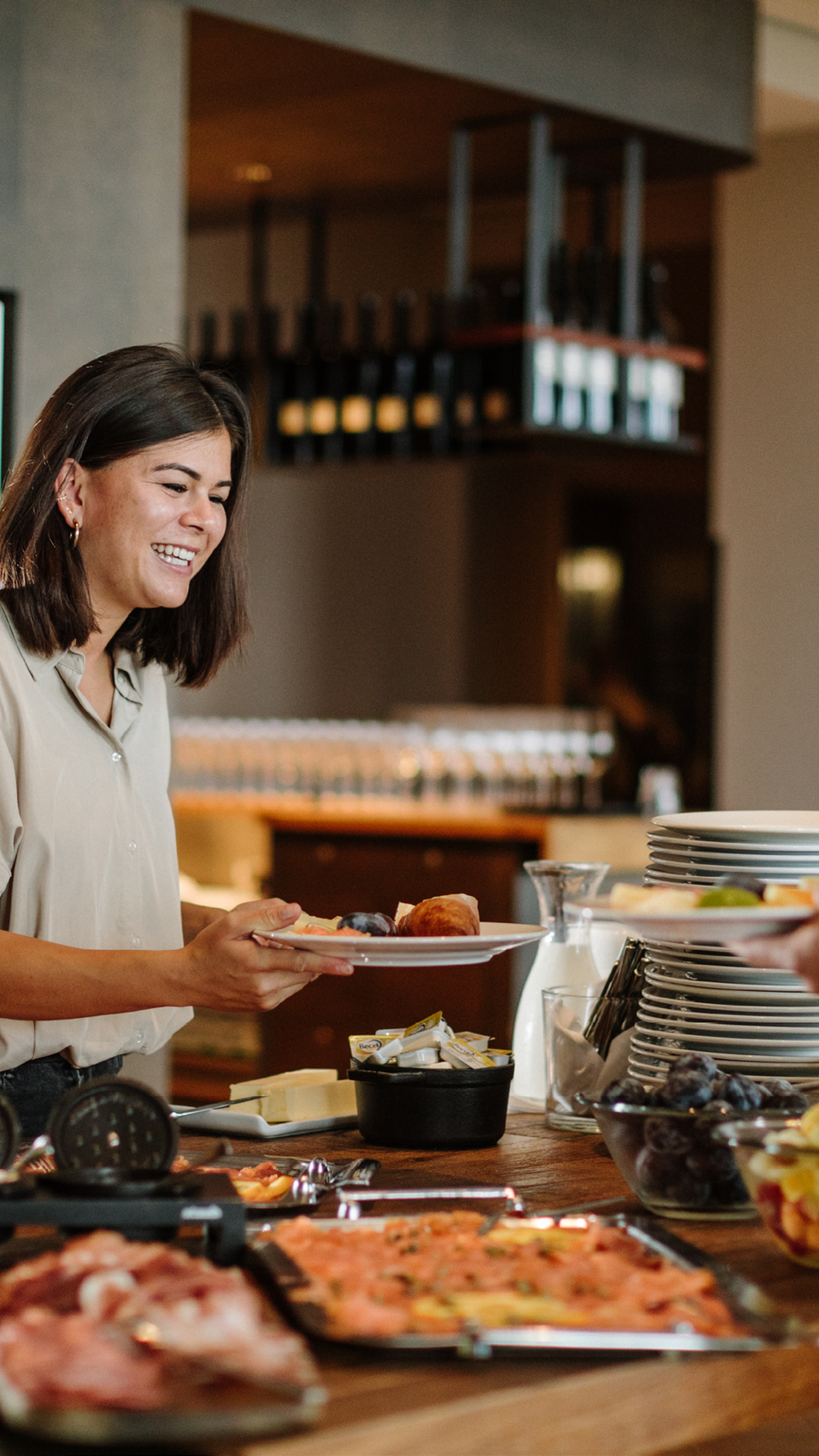 Frau steht am Sonntagsbrunchbuffet am Küchentisch im Restaurant Gurtners