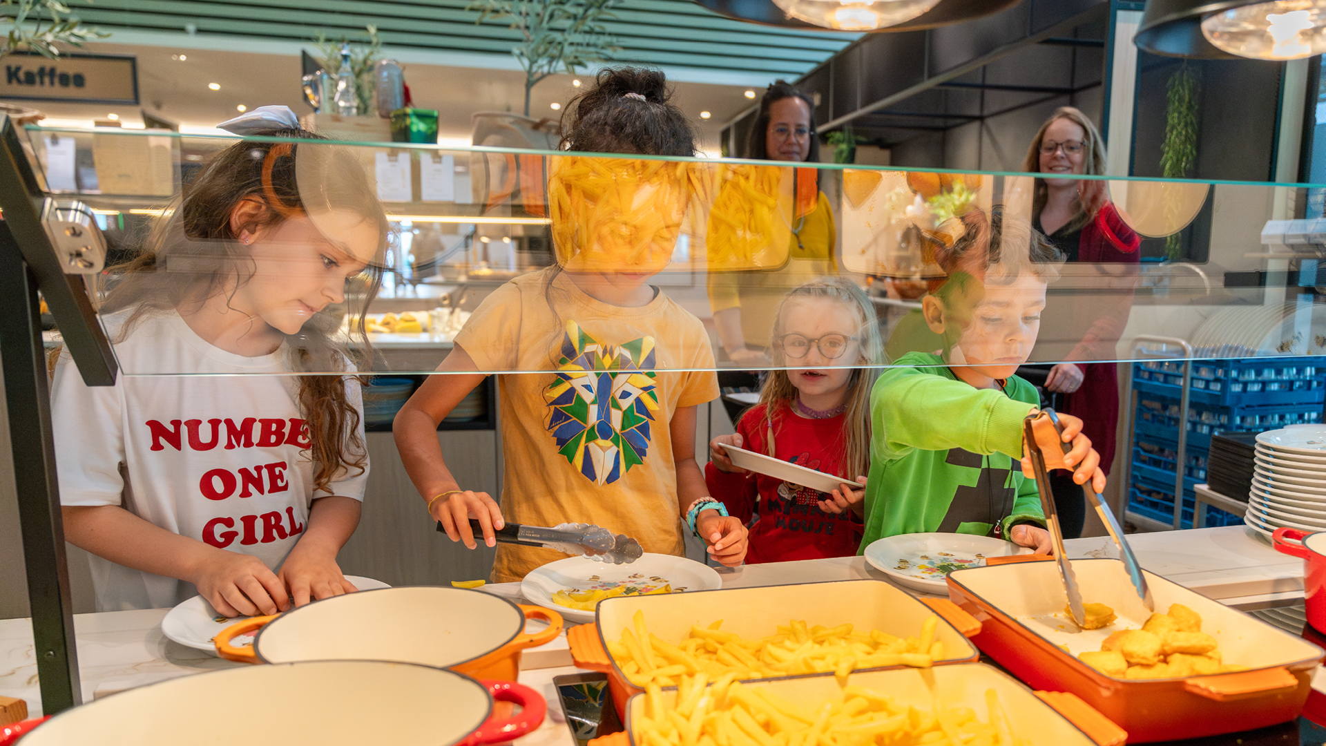 Vier Kinder welche sich gerade beim Kinderbuffet im Restaurant Huusbüffe bedienen.