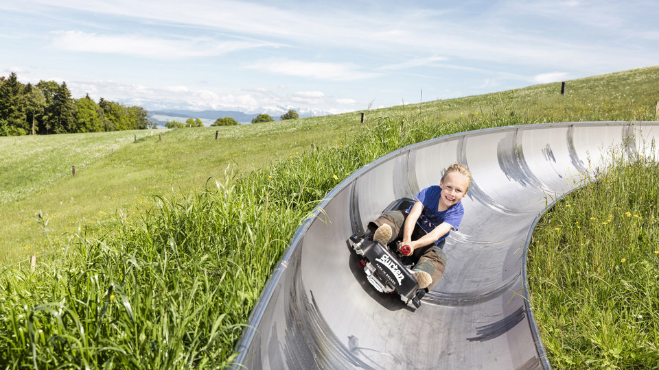 Ein Junge flitzt um die Ecke mit dem Rodel
