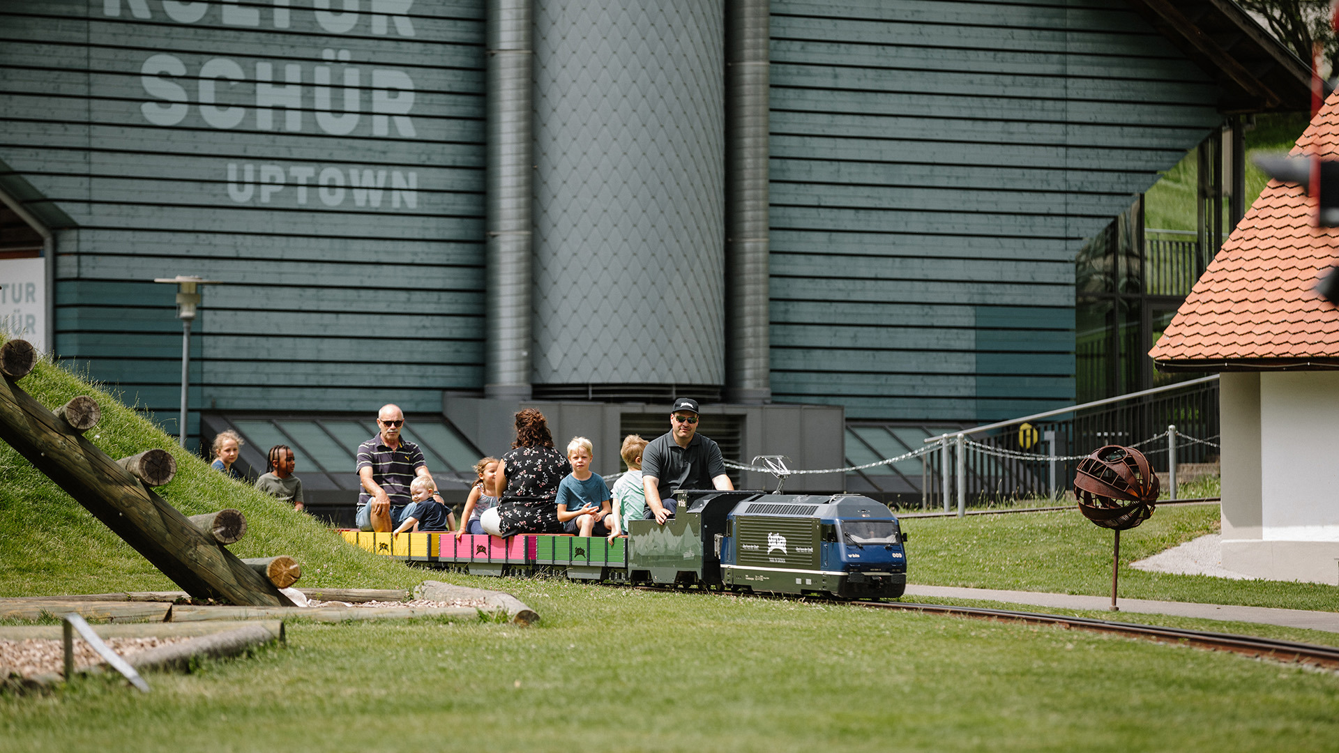 Kleineisenbahn fährt durch Spielpark mit vielen Passagieren