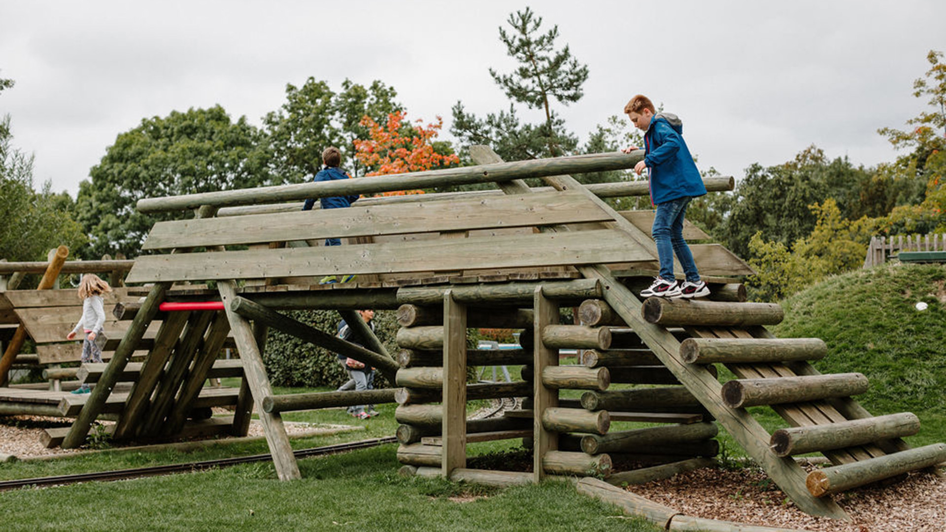 Structure d'escalade en bois au-dessus d'une voie ferrée pour petits trains