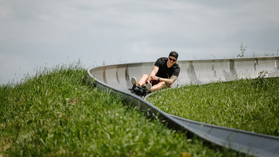 Ein Mann fährt die Rodelbahn hinunter