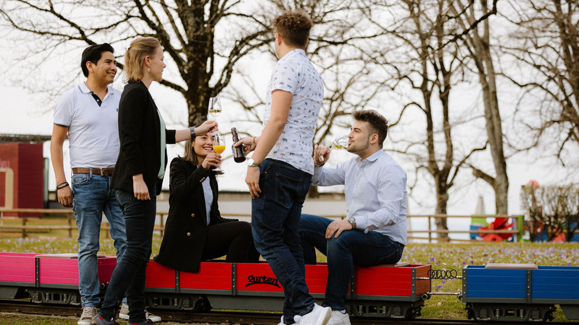 Fünf Menschen auf Kleineisenbahn im Apéro